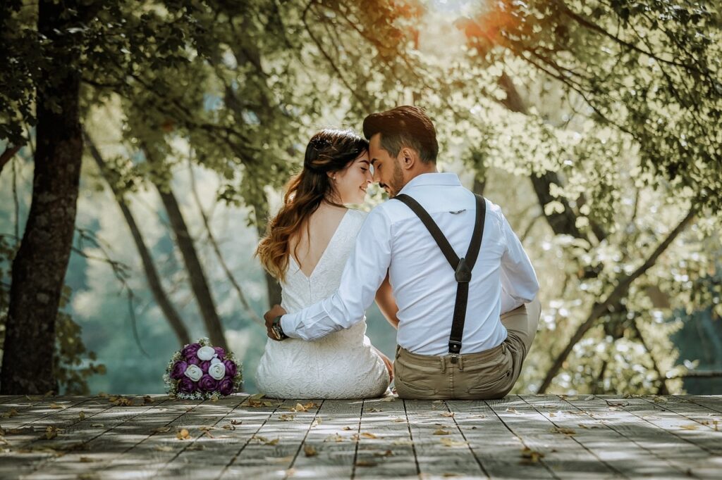 Wedding couple sitting by lake